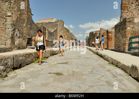 Feiner Blick auf die Straße, über Dell Abbondanza, die Touristen sind Audioführer hören, bei ihrem Besuch in Pompeji, Kampanien, Italien. Stockfoto