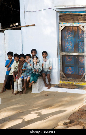 Kinder vor einem indischen Dorf nach Hause und Tür mit Schatten von Kindern ein Händeklatschen Spiel auf dem Boden spielen. Andhra Pradesh, Indien Stockfoto