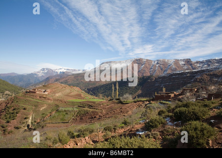 Marokko in Nordafrika Dezember Blick auf typische Lehmhütten einer Berber-Farm im Schnee bedeckt Atlasgebirge an einem schönen Wintertag Stockfoto