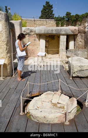 Touristische Führer ein Buch in einem Tempel in der archäologischen Stätte von Tarxien, Tarxien, Malta Stockfoto