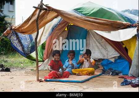 Glückliche armen indischen Kinder sitzen vor ihrem Zelt nach Hause. Andhra Pradesh, Indien Stockfoto