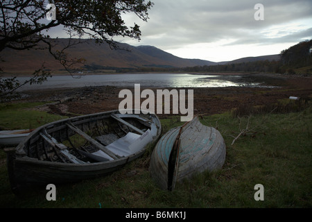 Am späten Nachmittag liegen unter grauem Himmel zwei verlassene Schlauchboote am Ufer der Applecross Bay, Stockfoto