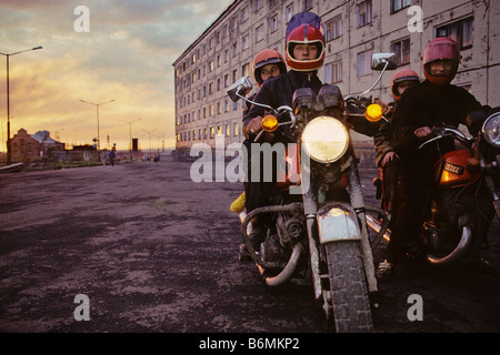 Zwei russische Motorradfahrer mit einem Reiter auf dem Rücken treiben in den Polarkreis Stadt Norilsk, Sibirien, Russland. Stockfoto