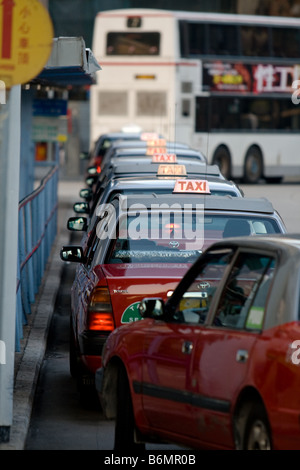 Taxis, Schlange, vor der Star Ferry Terminal und warten auf die Abend-Pendler in Kowloon, Hongkong. Stockfoto