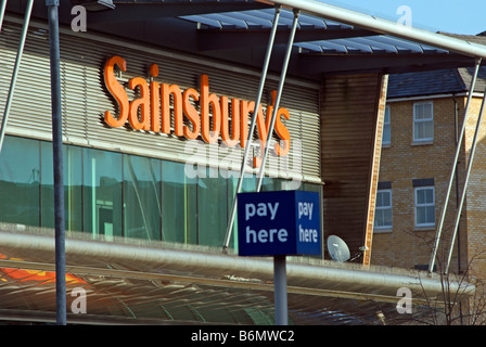 Außenseite des Sainsburys Supermarkt zeigt Logo speichern und Zahlen hier Parkplatz Zeichen in Kingston, Surrey, england Stockfoto