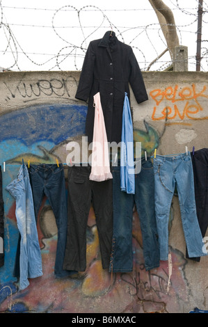 Kleidung zu verkaufen, hängen an der Wand mit Stacheldraht und Graffiti auf dem Flohmarkt von Saint Ouen, am Porte de Cignancourt, Paris Stockfoto