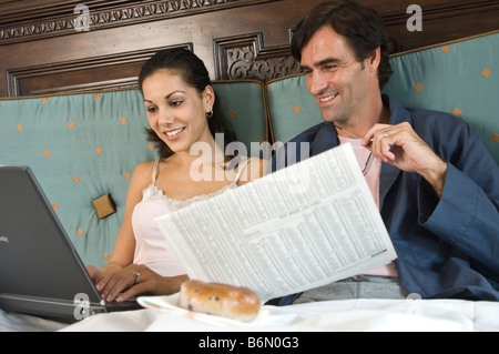 Paar im Bett mit computer Stockfoto
