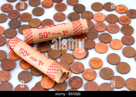 Konzept der Papier Münze Rollen neben Pennies auf weißem Hintergrund als Symbol für magere Zeiten Stockfoto