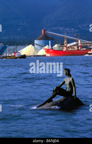 Mädchen in einen Neoprenanzug-Skulptur im Stanley Park und Frachter laden Schwefel in North Vancouver British Columbia Kanada Stockfoto