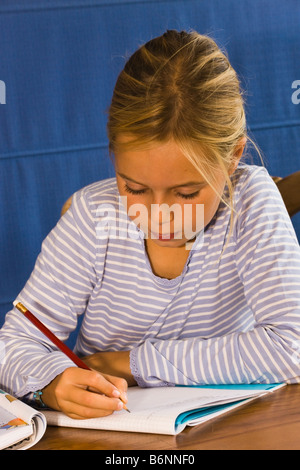 Neun Jahre altes Mädchen, die Konzentration auf ihre Hausaufgaben Stockfoto