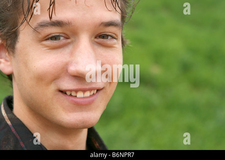 Closeup Portrait des jungen Mann arbeiten Front lächelnd mit grünen Rasen Hintergrund für textfreiraum Weichzeichnen Stockfoto