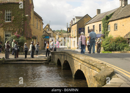 Japanische Touristen durch den Fluss Windrush & Mill Bridge in der malerischen Cotswold Dorf von Bourton-on-the-Water. Stockfoto