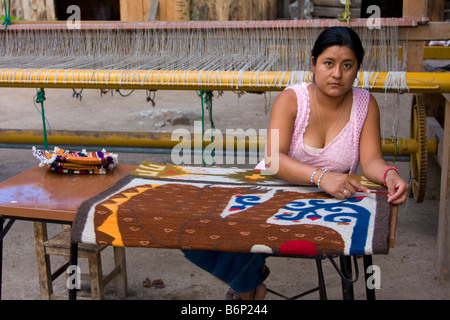 Santa Ana del Valle, Oaxaca, Mexiko. Zapoteken Indianerin auf Teppich oder Wandbehang mit Jaguar Design arbeiten. Stockfoto