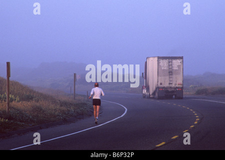 Läufer auf der Autobahn im Nebel mit LKW auf der Straße in der Nähe von Manila Samoa Halbinsel Humboldt County in Kalifornien Stockfoto