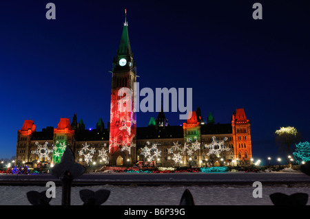 Ottawa Parlamentsgebäude Mittelblock beleuchtet von Weihnachtsbeleuchtung in ganz Kanada in der Dämmerung im Winter mit Schnee auf dem Parlamentshügel Stockfoto