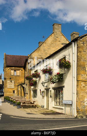 Der Adler und Kind Public House (mit Blumenampeln) neben dem Royalist Hotel - Stow-on-the-Wold, Gloucestershire. Stockfoto