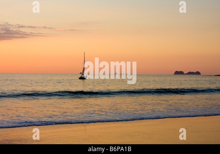 Segelboot direkt vor dem Strand bei Sonnenuntergang vor Flamingo Beach Costa Rica Stockfoto