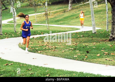 Zwei Schulmädchen heruntergekommen geschwungenen Gehweg im Park beim cross Country Rennen. Stockfoto