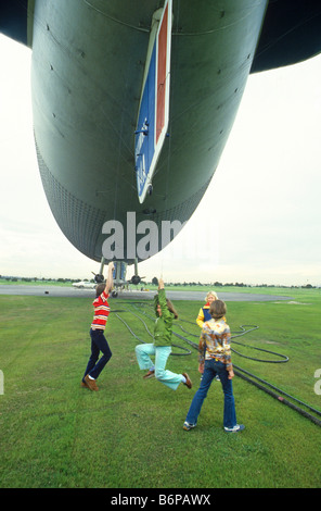 Kinder spielen mit Seilen unter Goodyear Blimp vor dem Schlafengehen für Fahrt in Handwerk, California Stockfoto