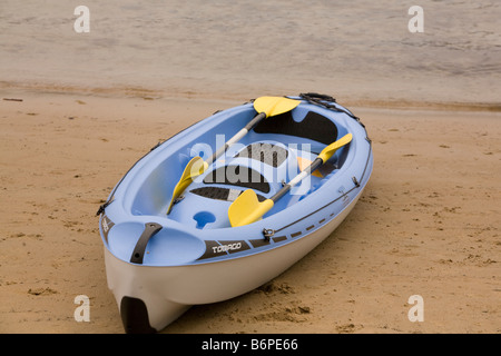 blaue Kajak liegt an einem Strand in Sydney mit seinen zwei Paddel liegen innerhalb des Bootes Stockfoto