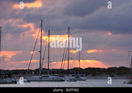 Die Sonne zwischen den Wolken hinter die Schiffe in der Insel Espalmador, einer kleinen Insel auf den Balearen verankert Stockfoto