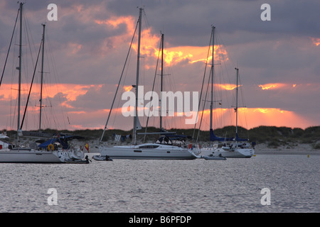 Die Sonne zwischen den Wolken hinter die Schiffe in der Insel Espalmador, einer kleinen Insel auf den Balearen verankert Stockfoto