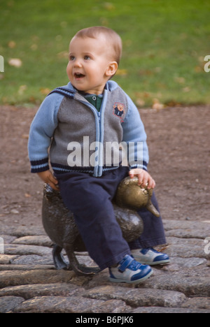 Kleiner Junge sitzt auf einer der machen Weg für Entenküken Skulptur in Boston Public Garden Stockfoto