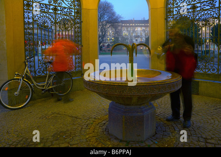 Zwei Männer am Kochbrunnen öffentliche Brunnen, ein natürliches warm Mineral spring bekannt für seine therapeutischen Eigenschaften Stockfoto