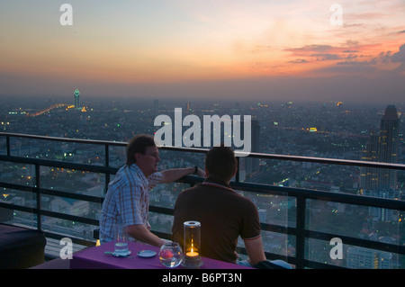 Touristen genießen Drinks bei Sonnenuntergang auf eine Dachterrasse mit Bar in Bangkok Thailand Stockfoto