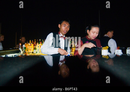 Barkeeper mixen Getränke in der Nacht auf eine Dachterrasse mit Bar in Bangkok Thailand Stockfoto