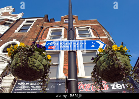 britische blau und weiß Zyklus Weg Zeichen mit Wegbeschreibungen und Entfernung zum Londoner Kensington und West end Stockfoto