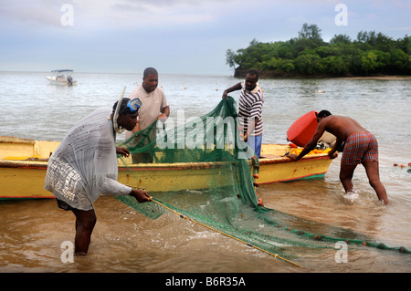 HANDWERKLICHE FISCHER SÄUBERN IHRE NETZE AM STRAND IM MORGAN BAY RESORT IN DER NÄHE VON CASTRIES, ST. LUCIA Stockfoto