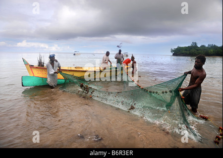 HANDWERKLICHE FISCHER SÄUBERN IHRE NETZE AM STRAND IM MORGAN BAY RESORT IN DER NÄHE VON CASTRIES, ST. LUCIA Stockfoto