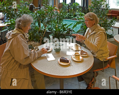 mittelalterlichen Frau besuchen ihre Mutter im Heim für alte Menschen mit Chat, trinken Kaffee, essen Kuchen Stockfoto