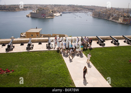 Touristen besuchen salutieren, Batterie, mit Blick auf Grand Harbour von Upper Barracca Gardens, Valletta, Malta Stockfoto