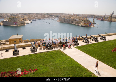 Touristen besuchen salutieren, Batterie, mit Blick auf Grand Harbour von Upper Barracca Gardens, Valletta, Malta Stockfoto