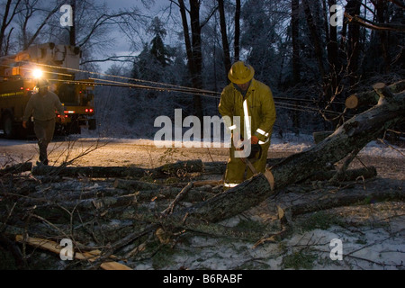 Dienstprogramm Arbeiter quer durch einen umgestürzten Baum auf Stromleitung Straße Stockfoto