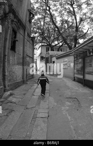 Chinesischen jungen laufen / überspringen durch historische Gasse Olkd c Stockfoto