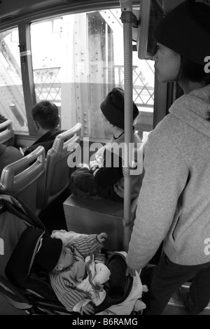 Junge Mutter mit zwei Kindern auf öffentlichen Stadtbus in Guanjgzhou China während der Weltwirtschaftskrise; Chinas ein-Kind-Politik Stockfoto