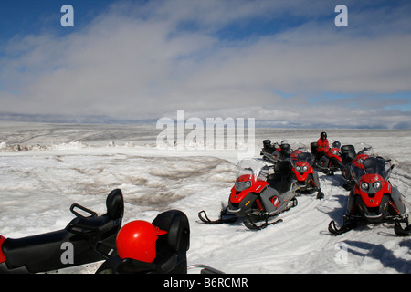 Menschen in roten Schutzkleidung auf dem vulkanischen Gletscher Mýrdalsjökull in Island auf Motorschlitten Stockfoto