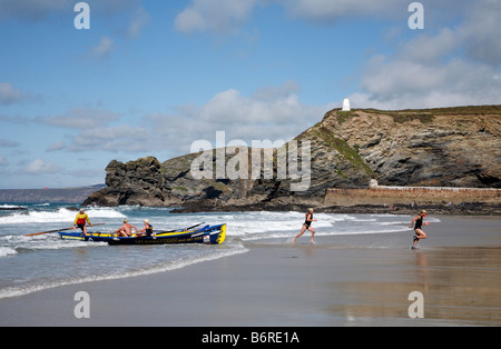 Konkurrenten aus dem Porthtowan Surf Boot Team eine Rennen in Portreath, Cornwall UK zu beenden. Stockfoto