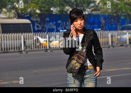 Frau zu Fuß mit ihrem Handy in Peking China Stockfoto