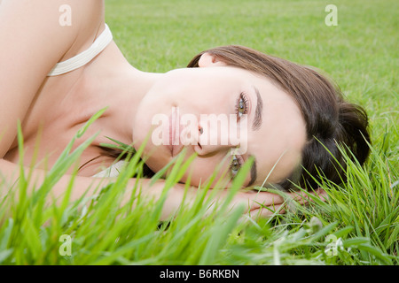 Junge Frau in langen Rasen liegen Stockfoto