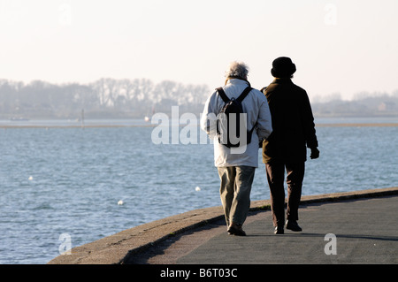 Ein älteres Ehepaar Fuß am Meer entlang auf Emsworth, West Sussex in England. Stockfoto