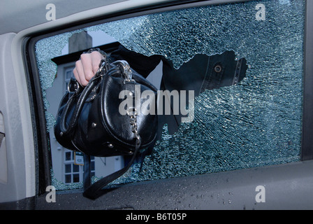 Eine Handtasche ist von der Rückbank eines Autos gestohlen, nach Zerschlagung der Treiber Seite Heckscheibe. Stockfoto