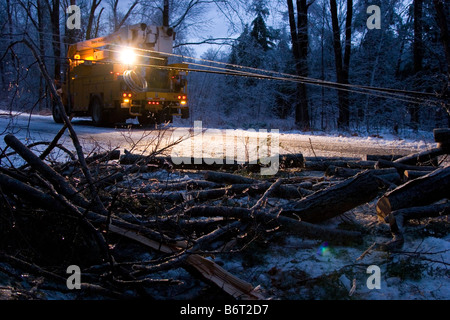 Utility Truck leuchtet einen umgestürzter Baum in der Fahrbahn in der Dämmerung im winter Stockfoto