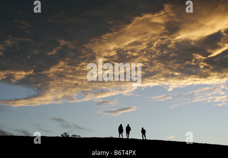 Gruppe von Personen auf einem Hügel bei Sonnenuntergang. Stockfoto