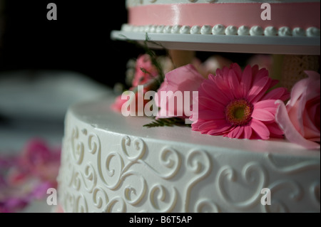 Rosenblätter verstreut eine Multi Tier Hochzeitstorte Stockfoto