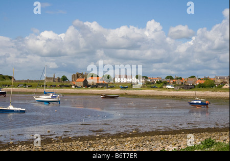 Blick vom Strand auf die heilige Insel Lindisfarne, Blick über die Bucht in Richtung Dorf und Lindisfarne Priory. Stockfoto