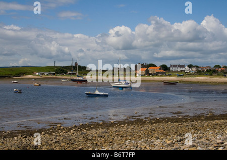 Blick vom Strand auf die heilige Insel Lindisfarne, Blick über die Bucht in Richtung Dorf und Lindisfarne Priory. Stockfoto